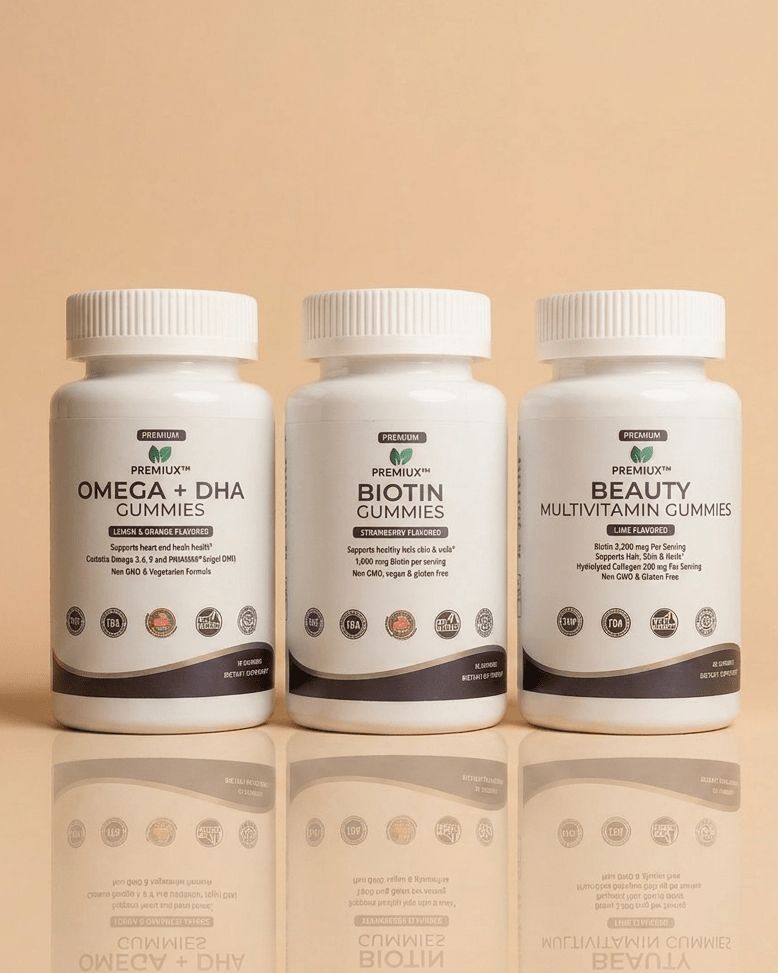The Glow Stack — Hair, Skin & Nails Bundle (Biotin + Beauty Multi + Omega-3) - Premiux NutritionThree white supplement bottles from Berenati's arranged side-by-side on a warm beige reflective surface. The bottles are labeled Omega + DHA Gummies, Biotin Gummies, and Beauty Multivitamin Gummies.